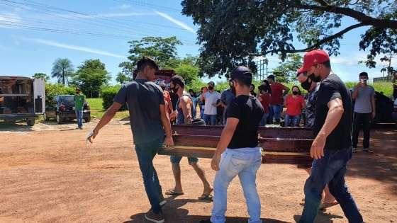 Familiares e amigos carregando os caixões
