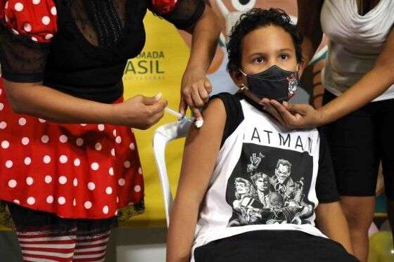 O pequeno Miguel Vieira Monteiro, de 9 anos, foi a primeira criança imunizada em Cuiabá nesta quinta-feira (20); ele possui neuropatia crônica e se enquadra no grupo de comorbidades