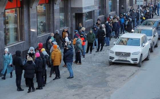 Pessoas fazem fila para usar um caixa eletrônico em São Petersburgo, na Rússia, no domingo (27)