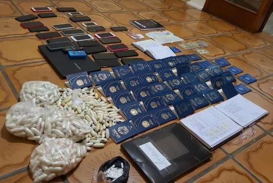 Drogas e passaportes apreendidos em casa onde 33 pessoas eram treinadas para engolir capsulas de cocaína.